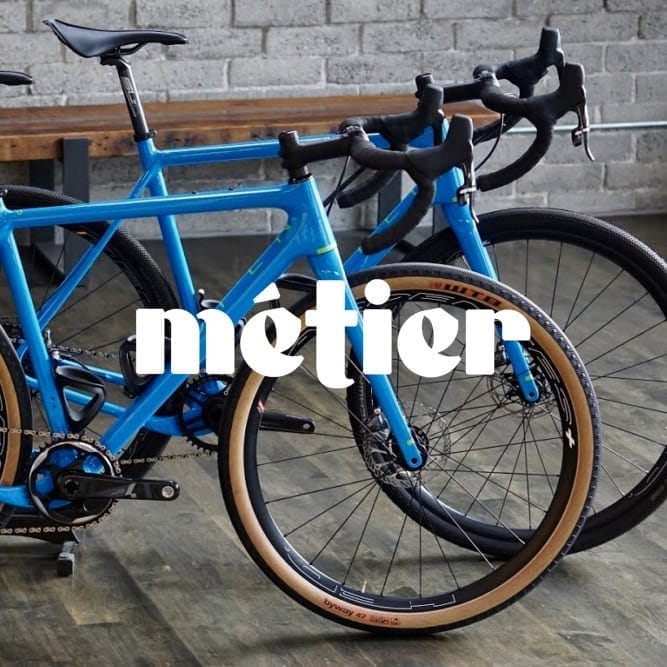 two blue bicycles with the metier logo