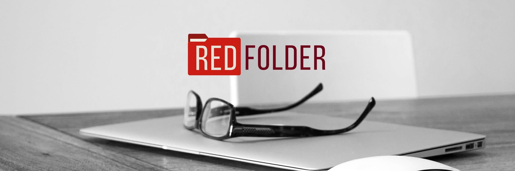 a pair of glasses on a laptop with the Redfolder logo